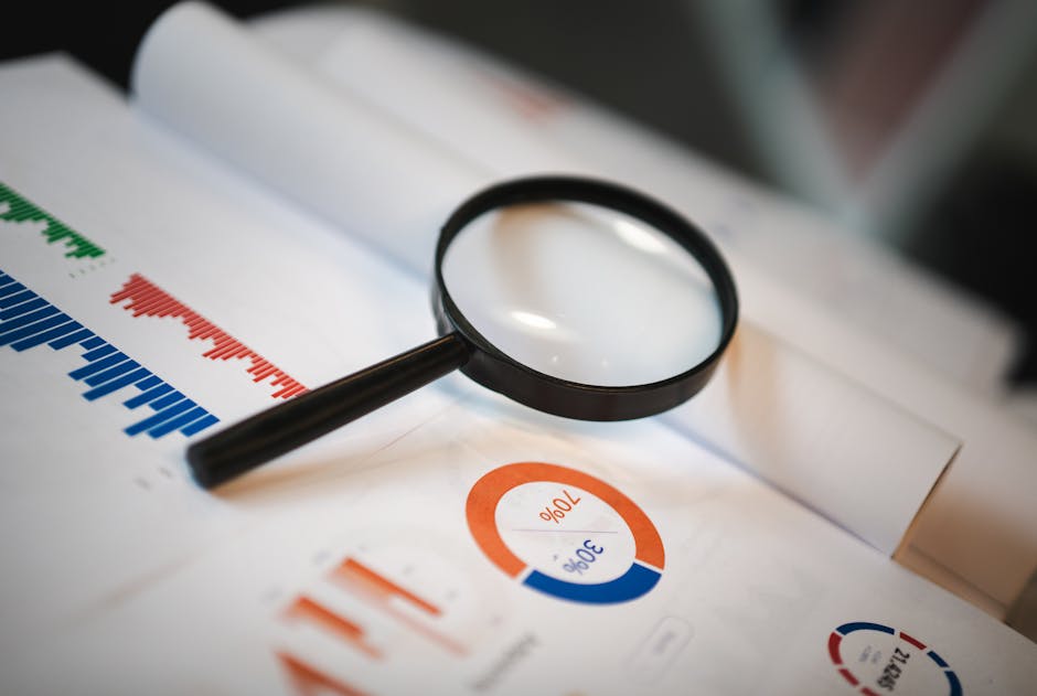pexels-photo-17284804-17284804 An image showcasing a magnifying glass placed on financial graphs and charts depicting statistical data.